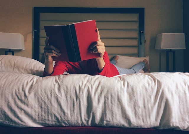 Žena číta knihu v posteli pred spaním